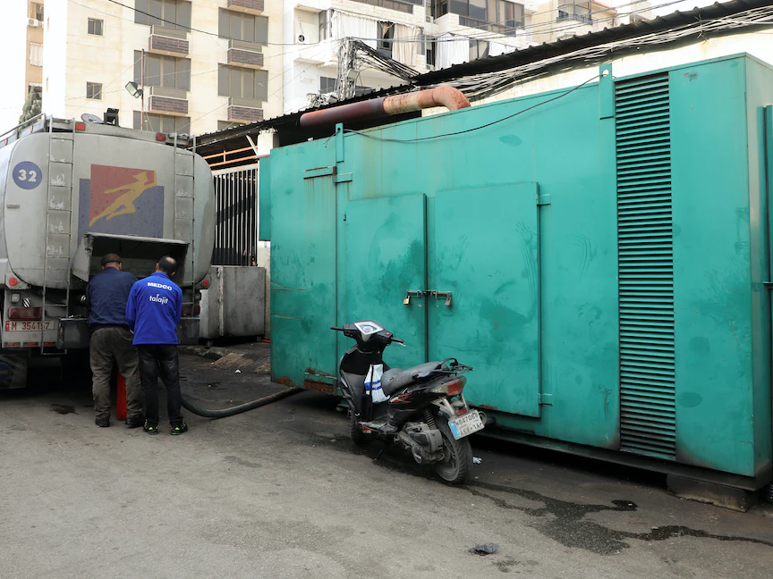 رجال يقومون بتعبئة مولداً خاصاً يوفر الكهرباء بزيت الديزل في بيروت، لبنان في 21 يناير 2022. - REUTERS