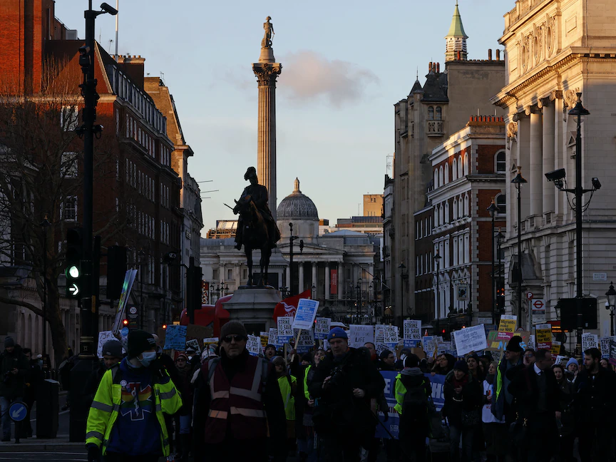 أشخاص يحملون لافتات أثناء إضراب ممرضات وغيرهم من العاملين الطبيين في لندن، بريطانيا- 18 يناير 2023 - AFP