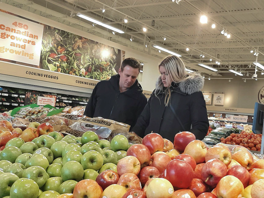 أشخاص يتسوقون لشراء الفواكه والخضروات في متجر بالعاصمة الكندية أوتاوا. 27 مارس 2023 - REUTERS