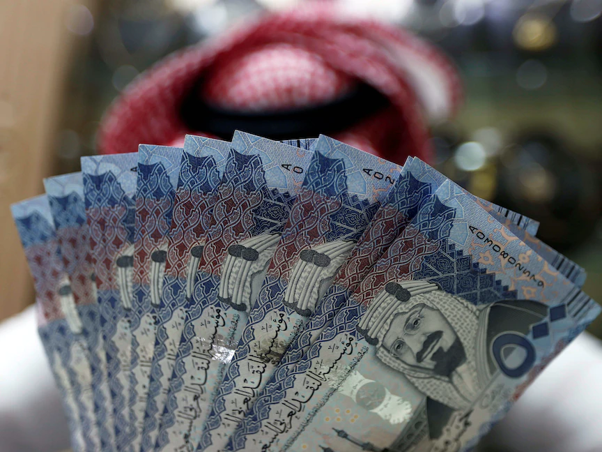 صراف سعودي يعرض عملات ورقية بالريال السعودي في أحد متاجر الصرافة في الرياض - REUTERS