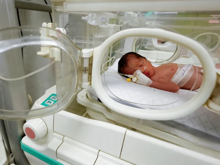 طفلة فلسطينية أنقذت من بطن والدتها التي توفيت جراء القصف إسرائيلي مع زوجها شكري وابنتها ملك، ترقد في حاضنة المستشفى الإماراتي برفح في جنوب قطاع غزة في 21 أبريل 2024. - ٌReuters