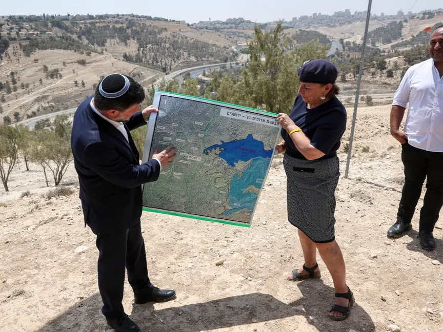 وزير المالية الإسرائيلي بتسلئيل سموتريتش يحمل خريطة تُظهر مخطط E1 الاستيطاني بالقرب من مستوطنة معاليه أدوميم شرق القدس المحتلة. 14 أغسطس 2025 - REUTERS