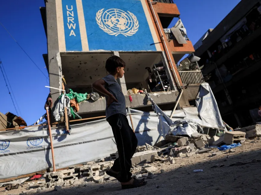 صبي فلسطيني يسير بالقرب من مدرسة تابعة للأونروا تؤوي النازحين بعد أن استهدفتها غارة إسرائيلية في مدينة غزة. 5 يوليو 2025 - Reuters