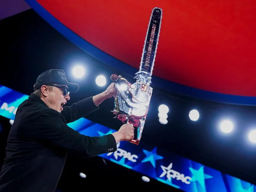 الملياردير الأميركي إيلون ماسك المسؤول السابق عن إدارة الكفاءة الحكومية يحمل منشاراً خلال مؤتمر العمل السياسي المحافظ CPAC في ولاية ماريلاند. 20 فبراير 2025 - REUTERS