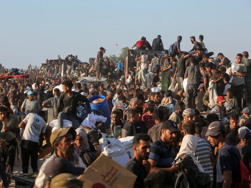 فلسطينيون يحملون إمدادات المساعدات في خان يونس جنوبي قطاع غزة. 4 أغسطس 2025 - REUTERS