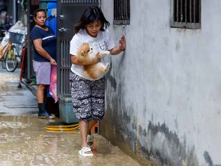 امرأة تسير في شارع موحل بعد الفيضانات التي تسبب بها الإعصار فونج وونج، مدينة ييلان، تايوان، 12 نوفمبر 2025 - Reuters