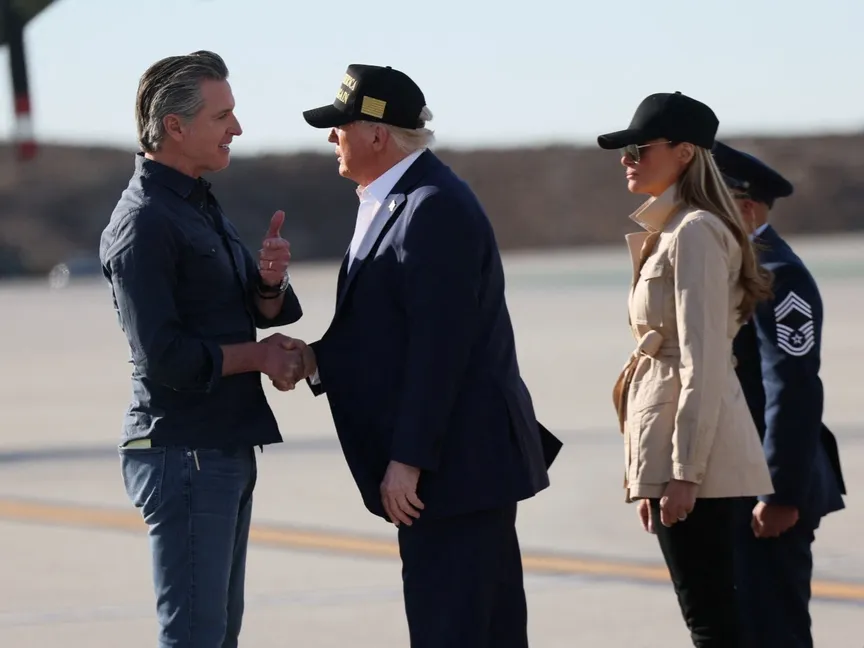 الرئيس الأميركي دونالد ترمب يصافح حاكم كاليفورنيا الديمقراطي جافين نيوسوم لدى وصوله في مطار لوس أنجلوس. 24 يناير 2025 - Reuters