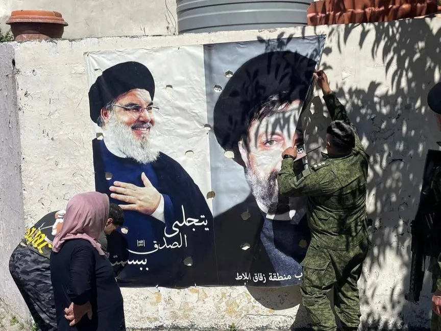 عناصر من شرطة البلدية يزيلون صورتين لأمين عام «حزب الله» السابق حسن نصر الله والإمام موسى الصدر (بلدية بيروت) - "الشرق الأوسط"