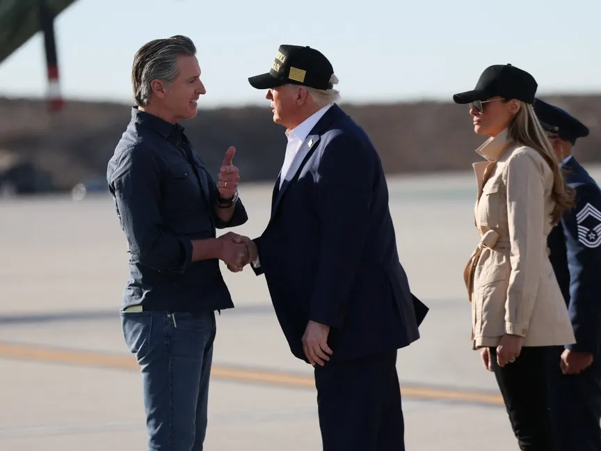 الرئيس الأميركي دونالد ترمب يصافح حاكم كاليفورنيا الديمقراطي جافين نيوسوم لدى وصوله في مطار لوس أنجلوس. 24 يناير 2025 - Reuters