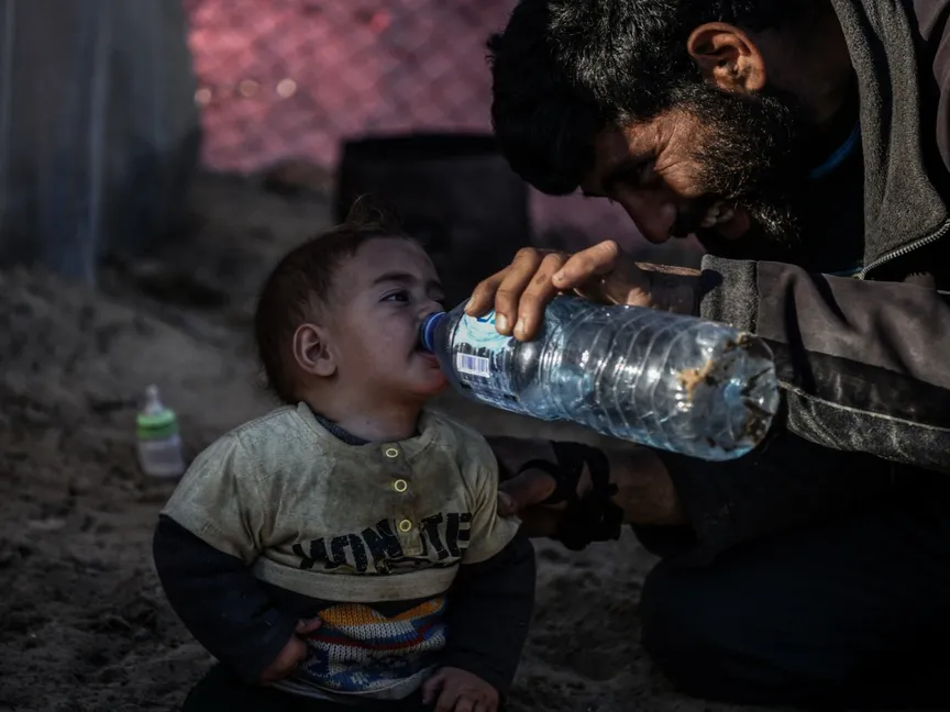 طفل فلسطيني يشرب الماء وسط كفاح النازحين من أجل العثور على مياه نظيفة في رفح، جنوب قطاع غزة. 9 فبراير 2024 - AFP