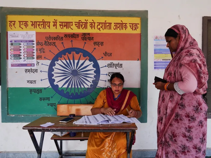 امرأة تتحقق من اسمها في قائمة التصويت خارج مركز اقتراع خلال الانتخابات التشريعية في كارنال بولاية هاريانا الشمالية في الهند. 5 أكتوبر 2024 - Reuters