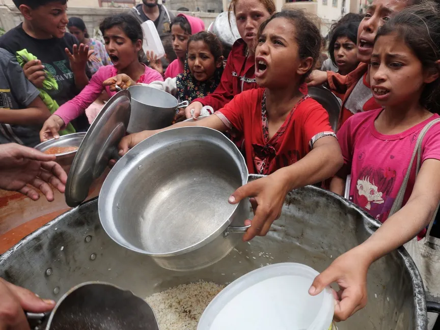فلسطينيون ينتظرون الحصول على طعام أعدته جمعية خيرية في النصيرات بوسط قطاع غزة. 8 أبريل 2025 - reuters
