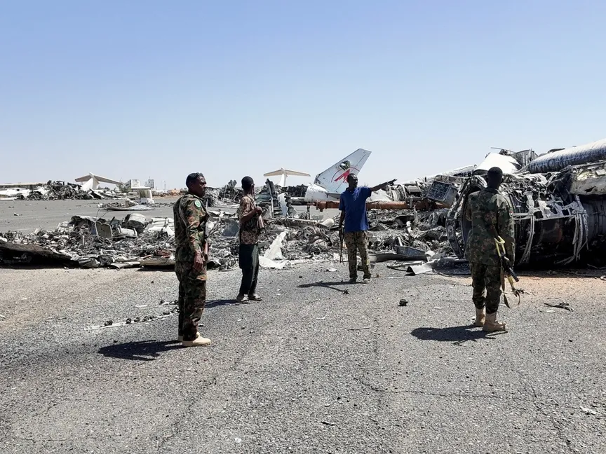 أفراد من الجيش السوداني بجانب حطام طائرة مدمرة على مدرج مطار الخرطوم. 27 مارس 2025 - REUTERS