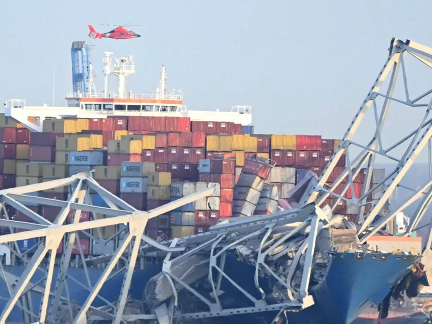 الإطار الفولاذي لجسر فرانسيس سكوت كي يقع فوق سفينة حاويات بعد انهيار الجسر في بالتيمور بولاية ماريلاند. 26 مارس 2024 - AFP