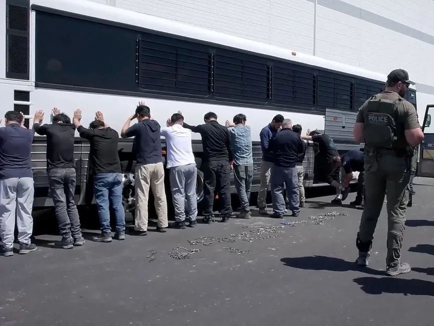 معتقلون يقفون أمام حافلة قبل تكبيلهم بالأصفاد خلال مداهمة قام بها عملاء فيدراليون في موقع مشروع لشركة هيونداي موتور وشركة إل جي إنرجي سوليوشن في جورجيا بالولايات المتحدة. 4 سبتمبر 2025 - Reuters