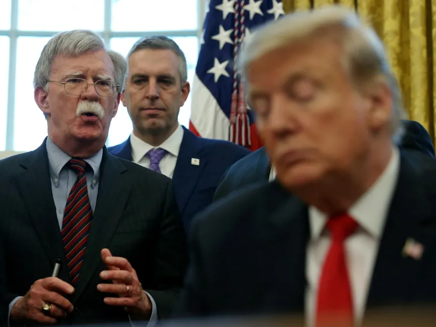 الرئيس الأميركي دونالد ترمب يستمع إلى مستشاره السابق للأمن القومي جون بولتون في البيت الأبيض. 7 فبراير 2019 - REUTERS