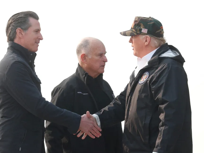 الرئيس الأميركي دونالد ترمب يصافح حاكم كاليفورنيا جافين نيوسوم لدى وصوله إلى قاعدة بيل الجوية في الولاية. 17 نوفمبر 2018 - Reuters