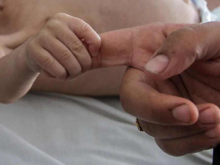 سيدة فلسطينية تمسك بيد ابنها البالغ من العمر 6 أشهر والذي يعاني من سوء تغذية في شمال قطاع غزة. 9 مايو 2024 - Reuters