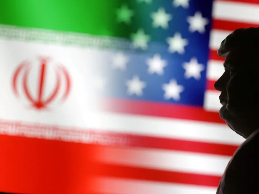 نموذج مصغر مطبوع بتقنية ثلاثية الأبعاد للرئيس الأميركي دونالد ترمب أمام علمي الولايات المتحدة وإيران. 15 يناير 2025 - REUTERS