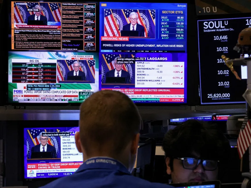 متداولون في أسواق الأسهم الأميركية يتابعون في نيويورك المؤتمر الصحافي لرئيس مجلس الاحتياطي الفيدرالي جيروم باول. 7 مايو 2025 - REUTERS