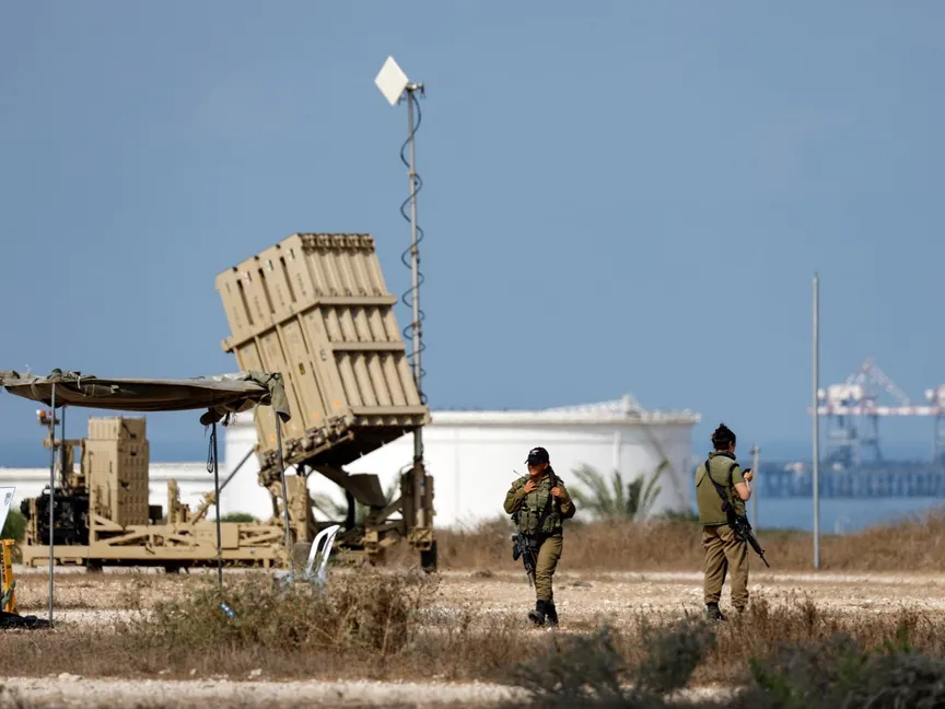جنود إسرائيليون يسيرون بجوار منظومة القبة الحديدية المضادة للصواريخ قرب الحدود مع غزة. 6 أغسطس 2022 - Reuters