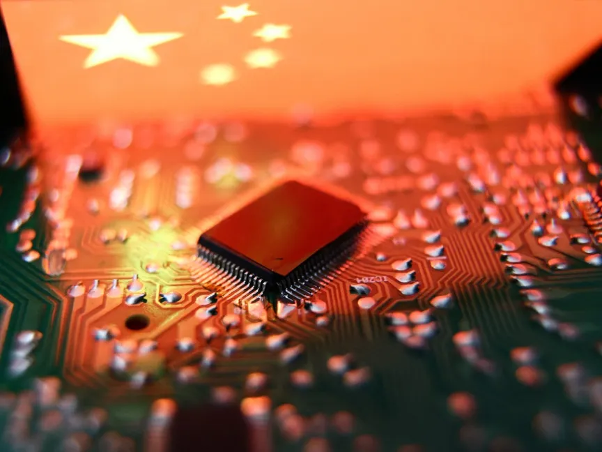 علم الصين معروض على شاشة هاتف وإلى جانبه رقاقة إلكترونية. 19 يوليو 2023 - AFP
