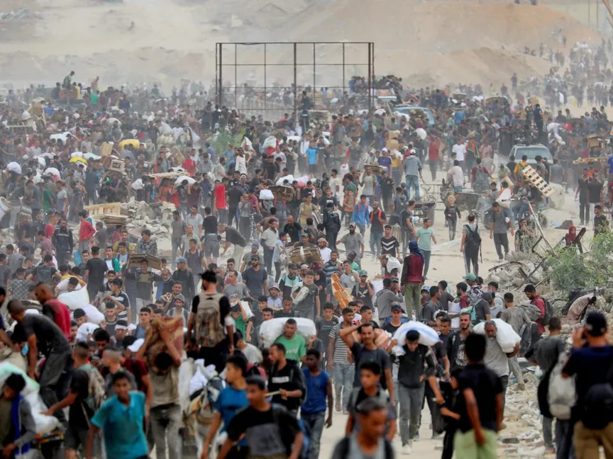 فلسطينيون يحملون مساعدات إنسانية وسط قطاع غزة. 1 أغسطس 2025 - Reuters