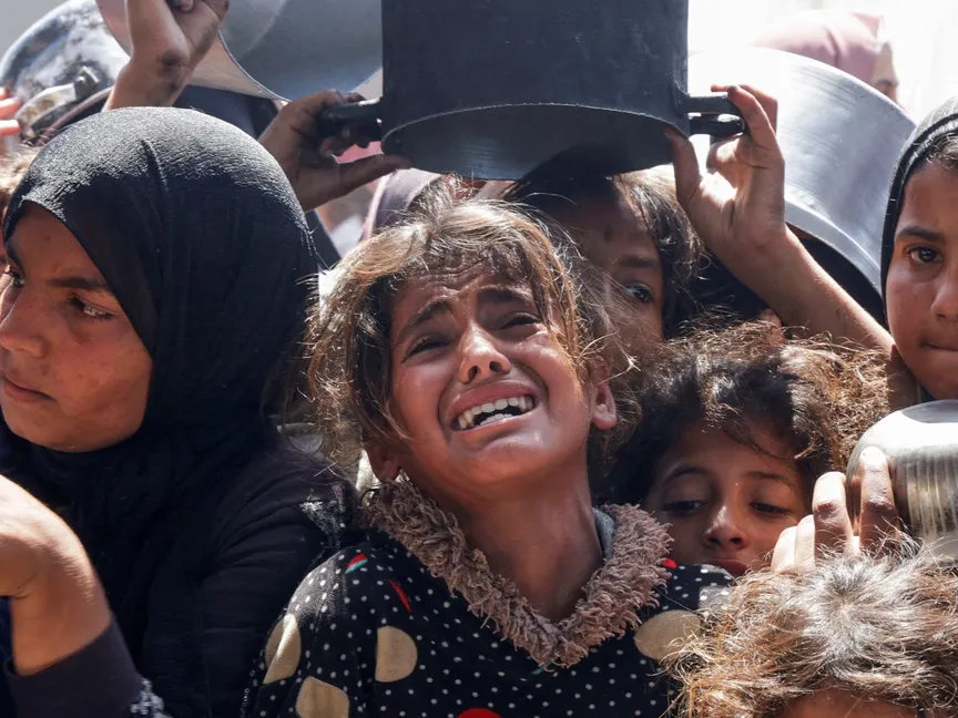 طفلة فلسطينية تبكي خلال محاولتها الحصول على طعام أعدته جمعية خيرية في خان يونس، جنوب قطاع غزة. 29 أبريل 2025 - Reuters