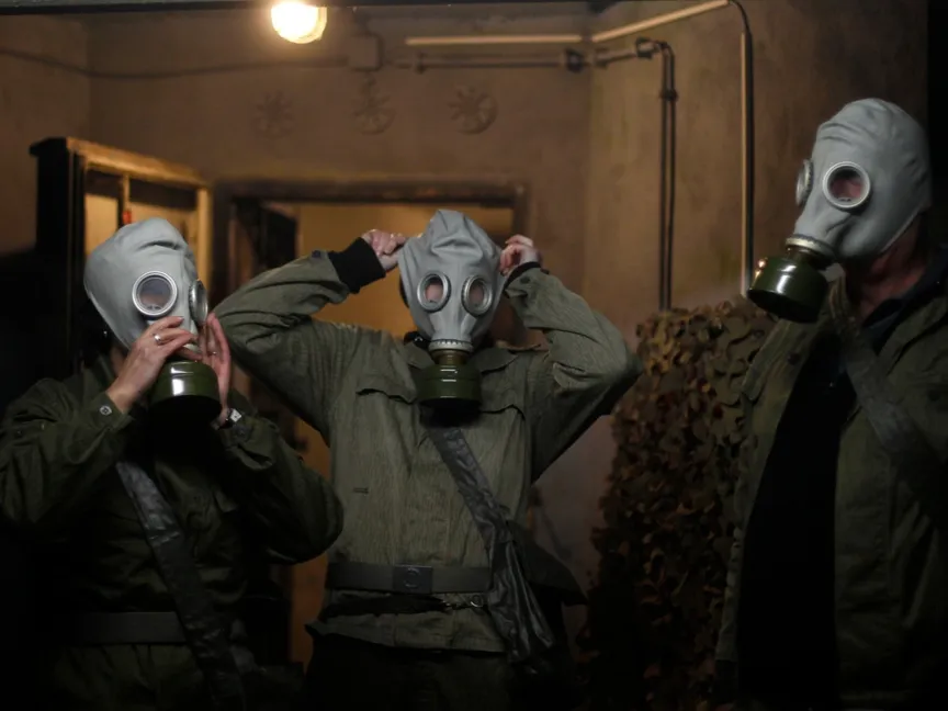 أفراد أسرة ألمانية يرتدون أقنعة واقية من الغازات خلال (محاكاة) داخل ملجأ محصن تحول إلى متحف قرب مدينة إلميناو بولاية تورينجن، وسط ألمانيا. 12 أكتوبر 2013 - REUTERS