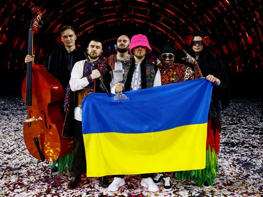 أعضاء فرقة "أوركسترا كالوش" يرفعون علماً أوكرانياً بعد فوزهم في مسابقة "يوروفيجن" للأغاني الأوروبية في تورينو - 15 مايو 2022 - REUTERS