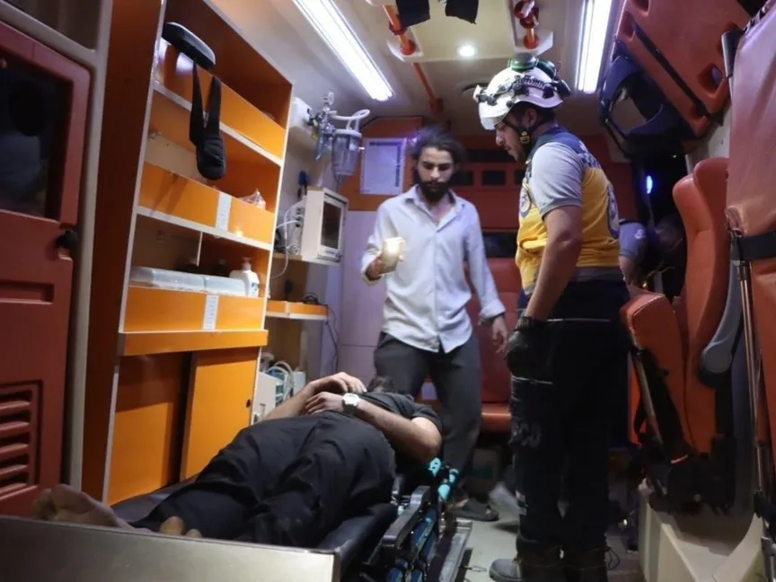 أحد المصابين في انفجار مستودع للذخيرة بأحد مواقع الجيش السوري في منطقة العيس بريف حلب الجنوبي يتلقى الإسعافات الأولية، 21 سبتمبر 2026 - وزارة الطوارئ السورية