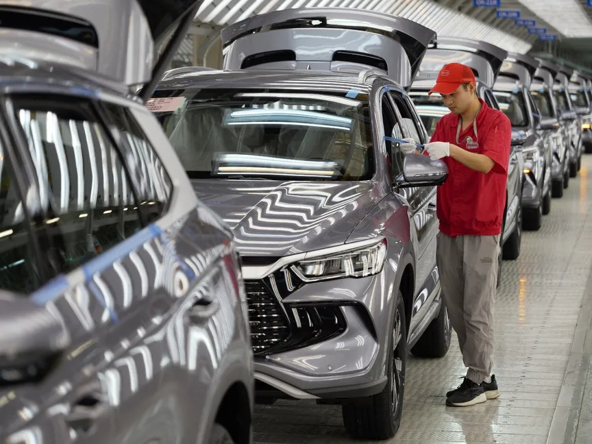 عامل يتحقق من جودة سيارة تعمل بالطاقة في مصنع شركة BYD الرائدة في الصين . 24 أبريل 2024 - AFP