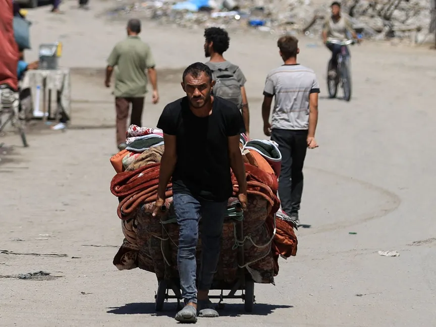 فلسطيني يجر متعلقات عائلته في رحلة نزوح جديدة في شمال قطاع غزة وسط هجمات إسرائيلية متصاعدة. 29 أغسطس 2025 - REUTERS
