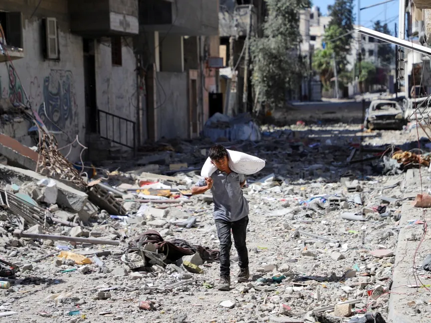 طفل فلسطيني يحمل مساعدات غذائية في حي الصبرة بمدينة غزة بشمال القطاع. 8 أكتوبر 2025 - REUTERS