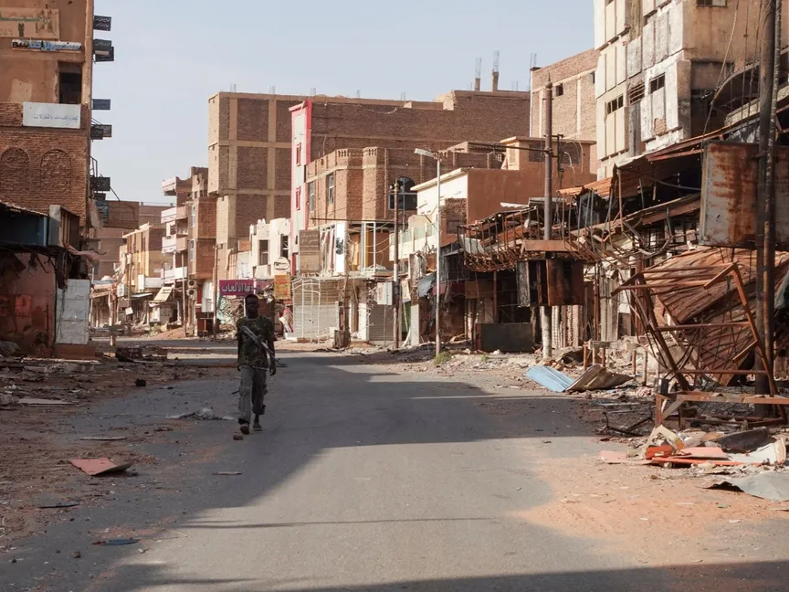 أحد أفراد القوات المسلحة السودانية يسير بين المباني المتضررة، بعد مرور عام تقريباً على الحرب بين القوات المسلحة السودانية وقوات الدعم السريع. أم درمان، السودان. 7 أبريل 2024 - Reuters