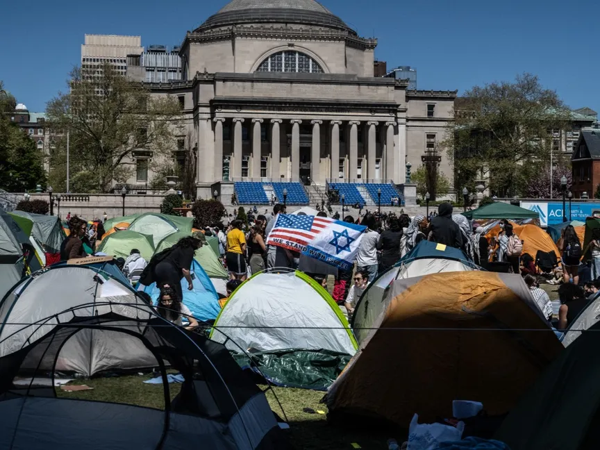 طلاب جامعة كولومبيا الأميركية في حرمهم الجامعي مع طالب مؤيد لإسرائيل يحمل العلم الإسرائيلي. 23 أبريل 2024 - AFP