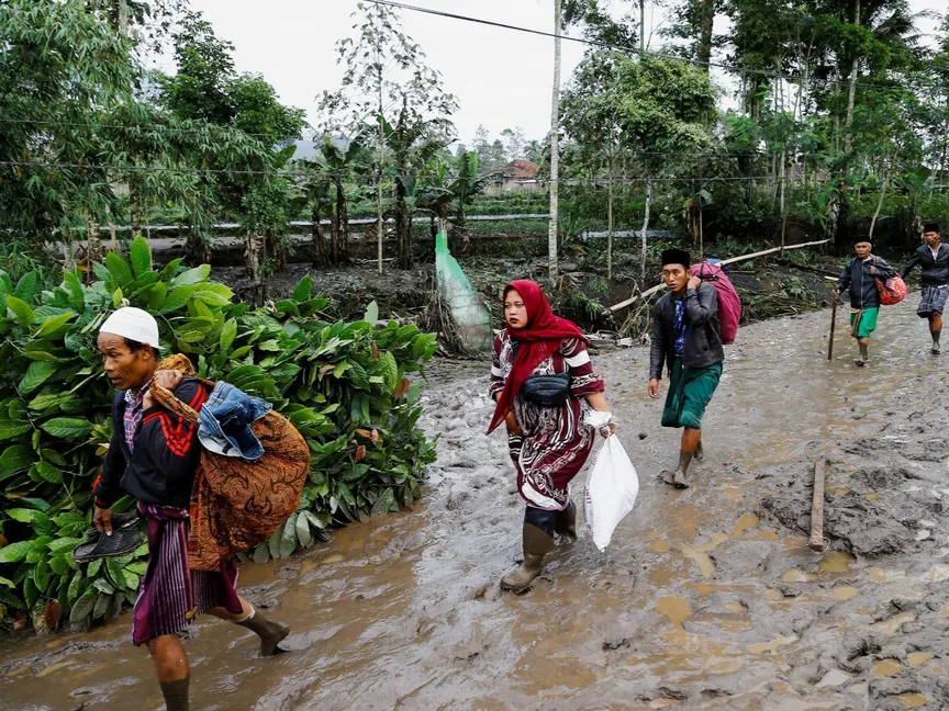 سكان محليون يخوضون في الطين بمقاطعة جاوة الشرقية في إندونيسيا. 20 نوفمبر 2025 - REUTERS