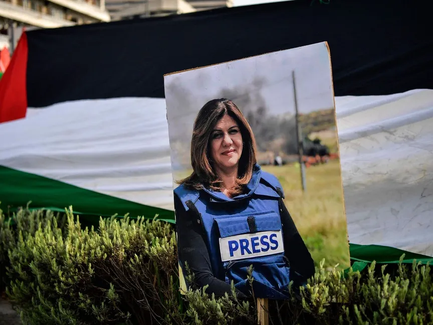 صورة الصحافية شيرين أبو عاقلة أمام العلم الفلسطيني خلال احتجاجات أمام السفارة الإسرائيلية بالعاصمة اليونانية أثينا - 16 مايو 2022 - AFP