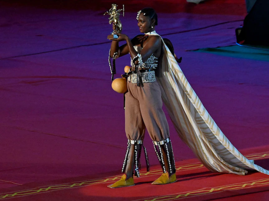 امرأة تحمل جائزة "الجواد الذهبي" في مهرجان "فيسباكو" قبل إعلان فوز المخرج الصومالي في واجادوجو، عاصمة بوركينا فاسو. 23 أكتوبر 2021 - AFP