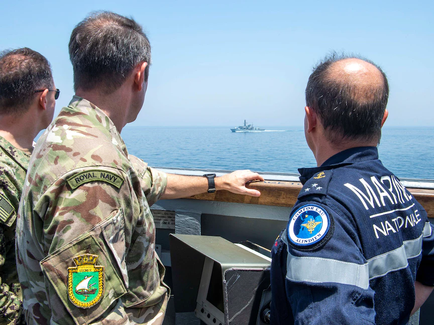 ضباط أميركيون وبريطانيون يراقبون قطعة بحرية حربية تعبر مضيق هرمز. 19 مايو 2023 - REUTERS