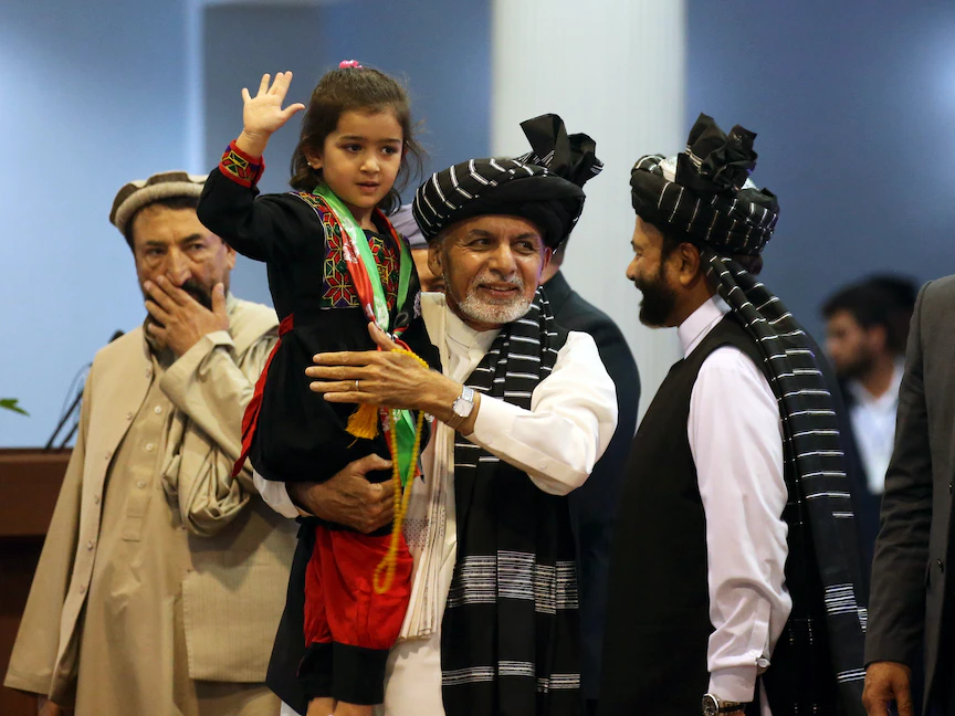 أشرف غني يحمل فتاة خلال تجمّع انتخابي في كابول - 13 سبتمبر 2019 - REUTERS