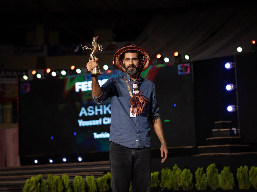 شخص يلوح بجائزة المخرج التونسي يوسف الشابي التي تسلمها نيابة عنه خلال الحفل الختامي للمهرجان الإفريقي الـ28 للسينما والتلفزيون (FESPACO) في واجادوجو عاصمة بوركينافاسو. 4 مارس 2023 - AFP