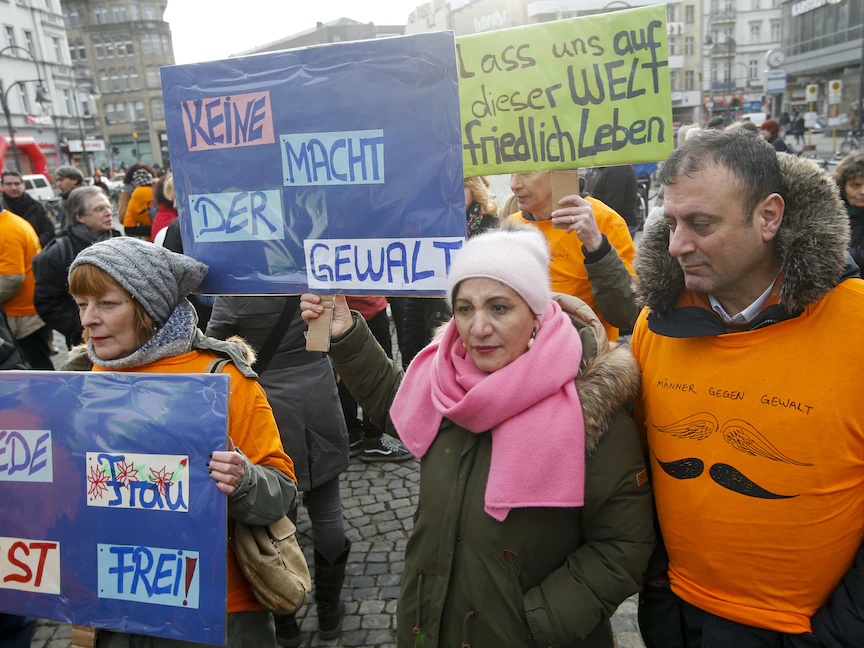 أشخاص يحملون لافتات خلال مظاهرة تضامنية ضد العنف ضد المرأة في برلين، ألمانيا. 16 يناير 2016 - REUTERS