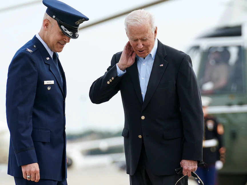 الرئيس الأميركي جو بايدن يحاول إبعاد "زيز" كان يطير حول رأسه قبل ركوب طائرة الرئاسة متوجهاً إلى لندن - 9 يونيو 2021 - REUTERS