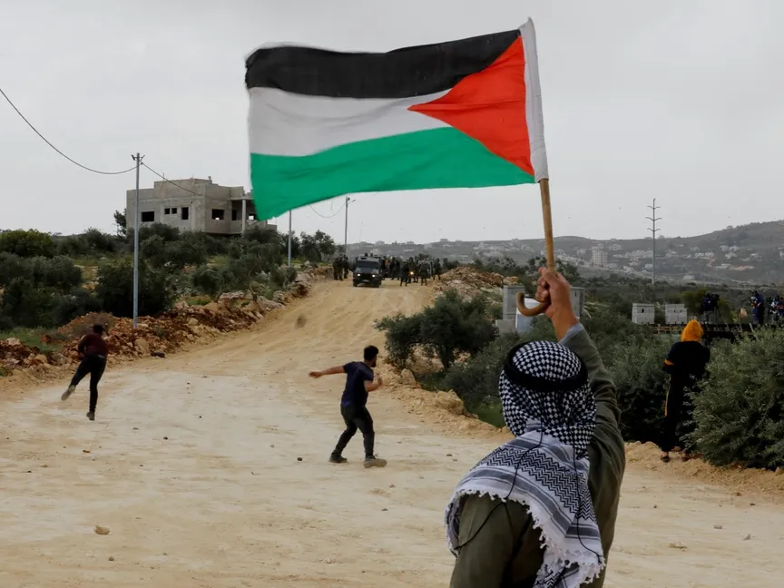 متظاهر يحمل العلم الفلسطيني خلال اشتباكات مع القوات الإسرائيلية في نابلس بالضفة الغربية. 10 أبريل 2023 - REUTERS