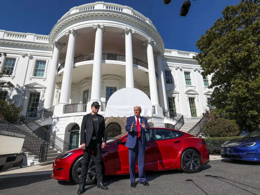 الرئيس الأميركي دونالد ترمب والرئيس التنفيذي لشركة تسلا إيلون ماسك يقفان أمام سيارة تسلا في البيت الأبيض. 11 مارس 2025 - REUTERS