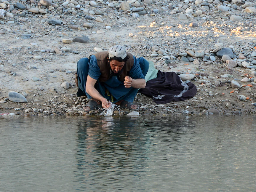 أفغاني يتوضأ في نهر قبل أداء صلاته في أرغنداب بالجزء الأوسط من مقاطعة قندهار - 12 فبراير 2022 - AFP