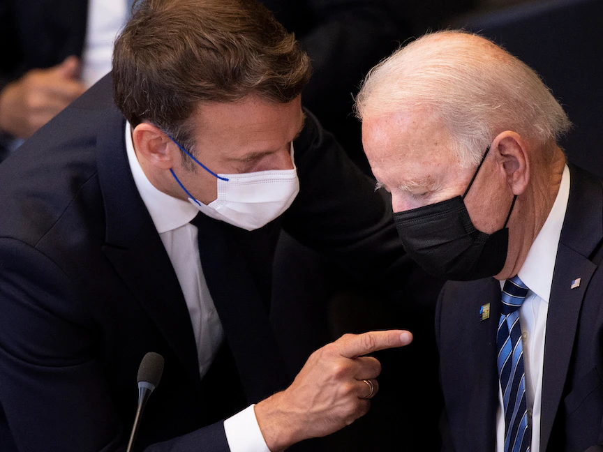 الرئيس الفرنسي إيمانويل ماكرون يتحدث مع الرئيس الأميركي جو بايدن قبل جلسة عامة في قمة "الناتو" في بروكسل، بلجيكا، 14 يونيو 2021 - REUTERS
