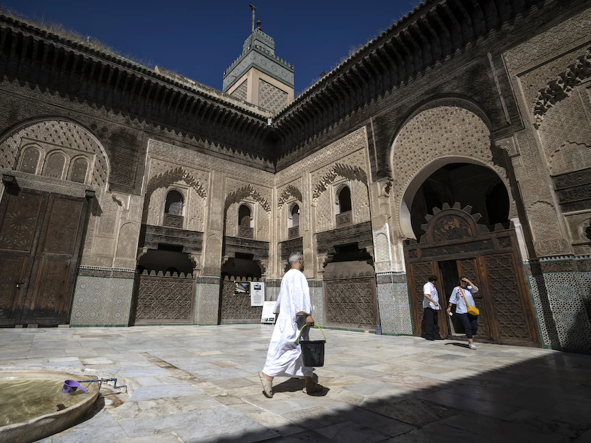 يقوم الزوار بجولة في مدرسة البوعنانية الواقعة بمدينة فاس المغربية القديمة - 8 يونيو 2022 - AFP