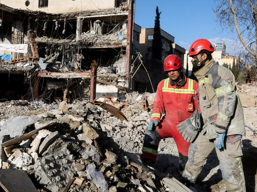 أعضاء فريق إنقاذ تابع للهلال الأحمر الإيراني يعملون عند مبنى تضرر جراء غارة في العاصمة طهران. 21 مارس 2026 - Reuters